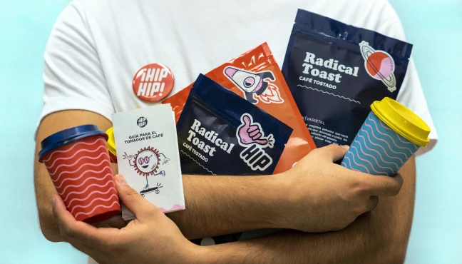 Person holding assorted branded snack packages and takeaway cups.